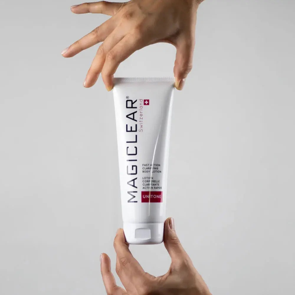 Mains tenant le lait corps anti-taches Magiclear, texture légère non grasse qui hydrate intensément l'ensemble du corps